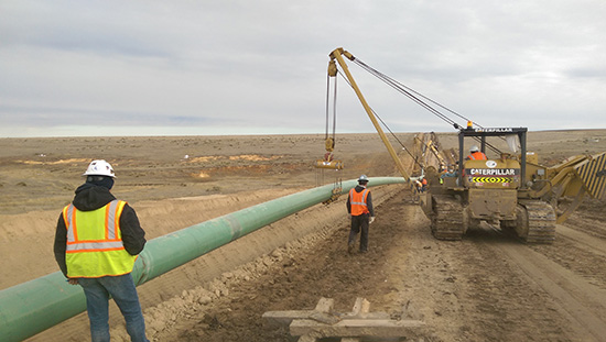 A newly constructed pipeline being lowered into the ground