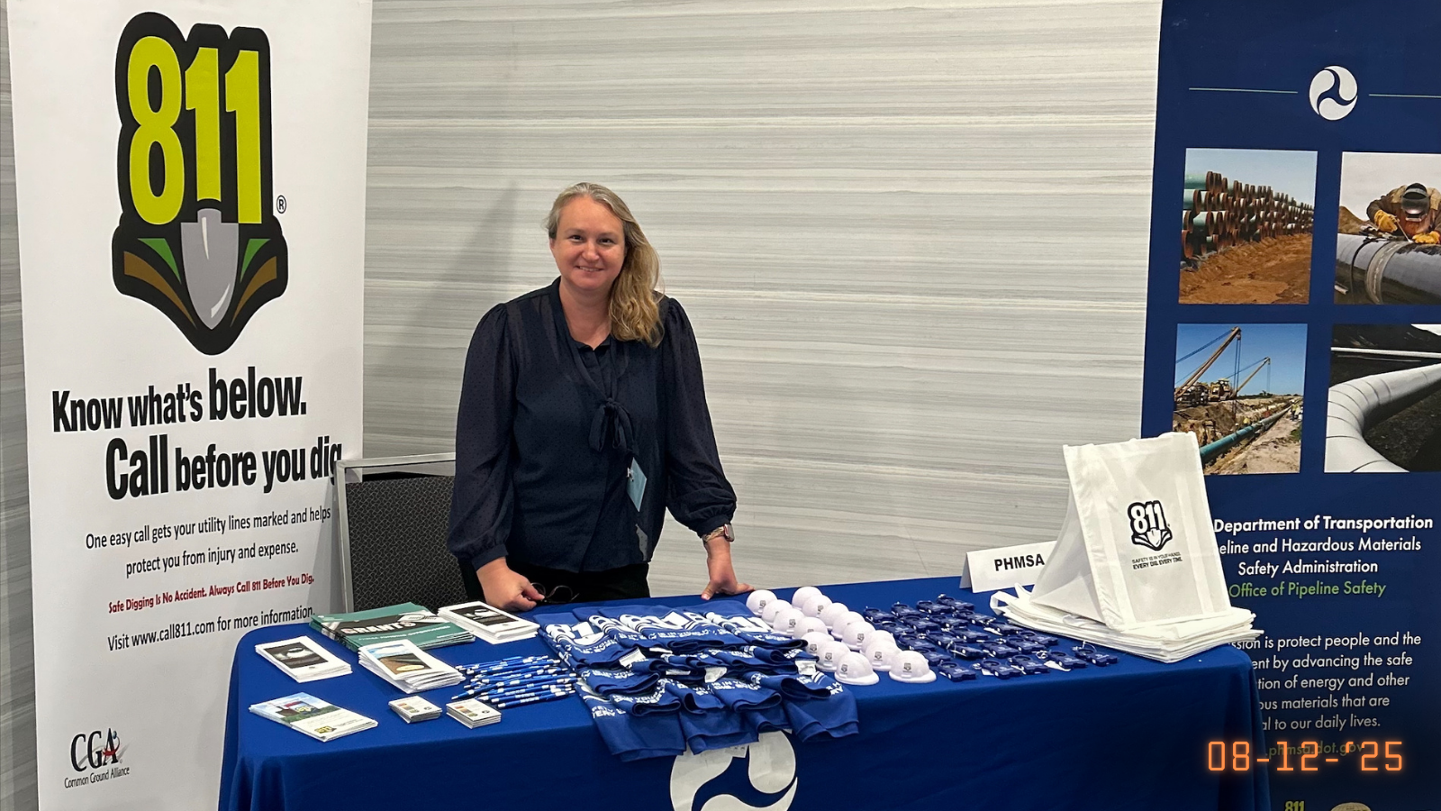 Photo of PHMSA representative standing in front of 811 display table